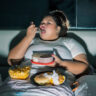 Person lying awake and eating at night struggling with poor sleep and weight loss challenges